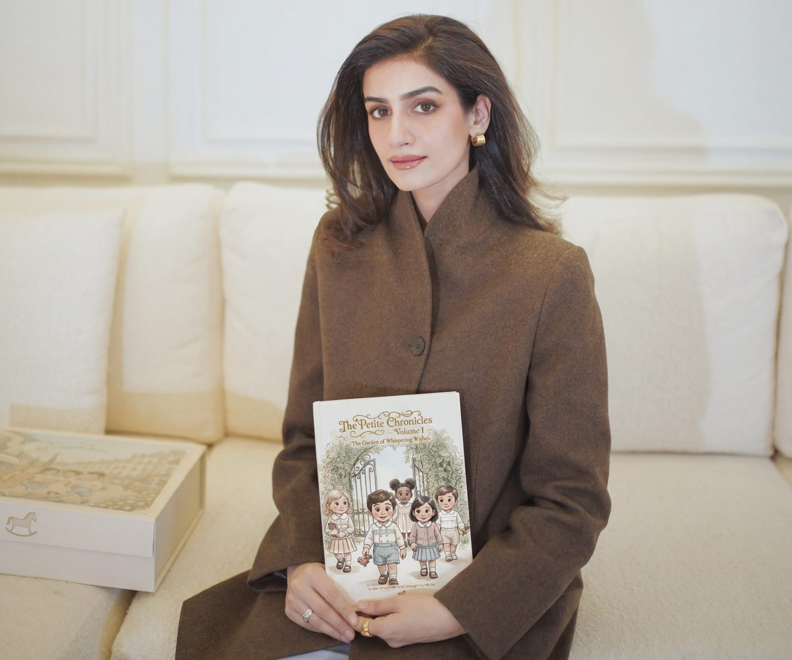 Sameen holding The Petite Chronicles storybook